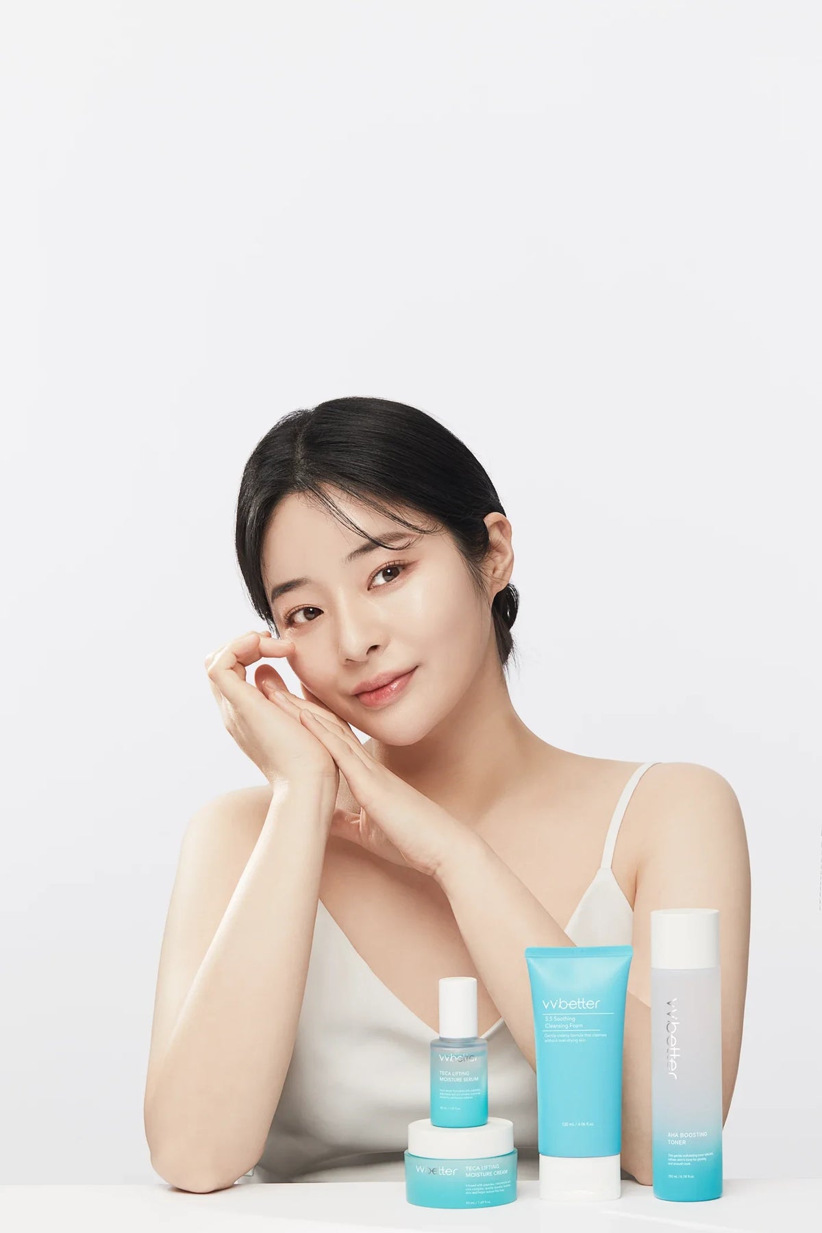 A model resting her chin on her hands beside a Blue Line cleansing foam, toner, serum and cream