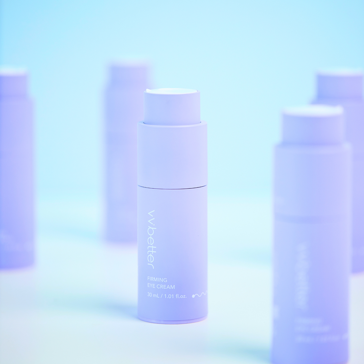Firming Eye Cream — bottles standing on a pale blue backdrop, angle view