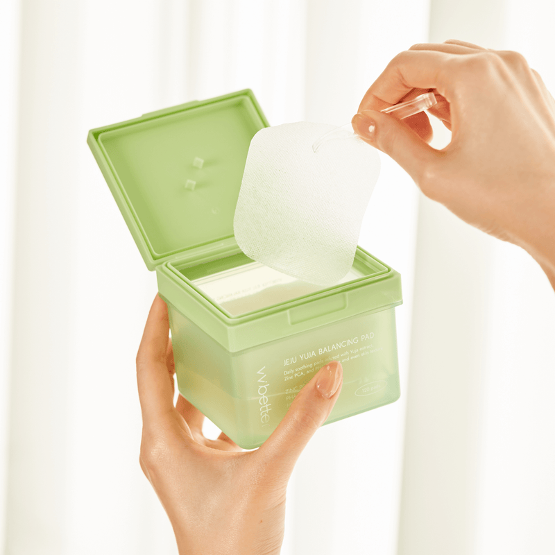 Jeju Yuja Balancing Pad — one pad lifted from the open jar with the tweezers