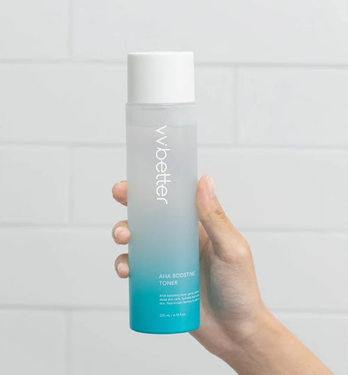 Hand holding the AHA Boosting Toner bottle