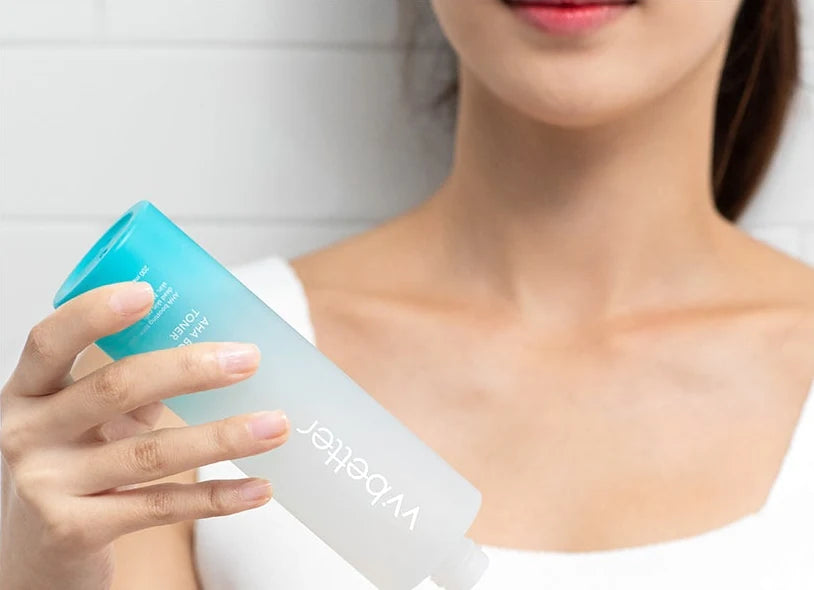 Woman tilting the AHA Boosting Toner bottle