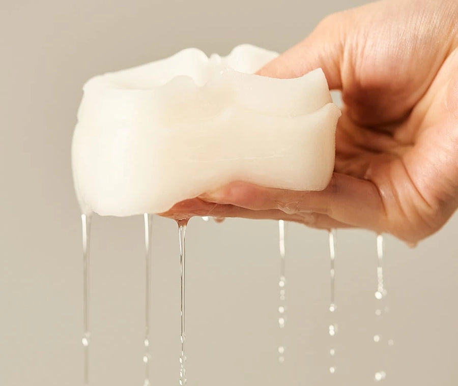 Hand squeezing a stack of pads, essence dripping
