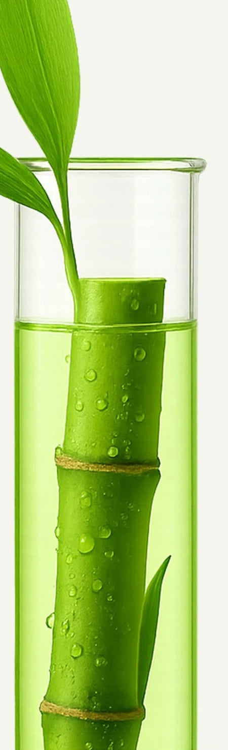 Bamboo stalk standing in a glass beaker of green liquid