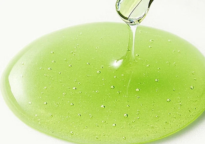 Dropper releasing clear green serum into a small puddle