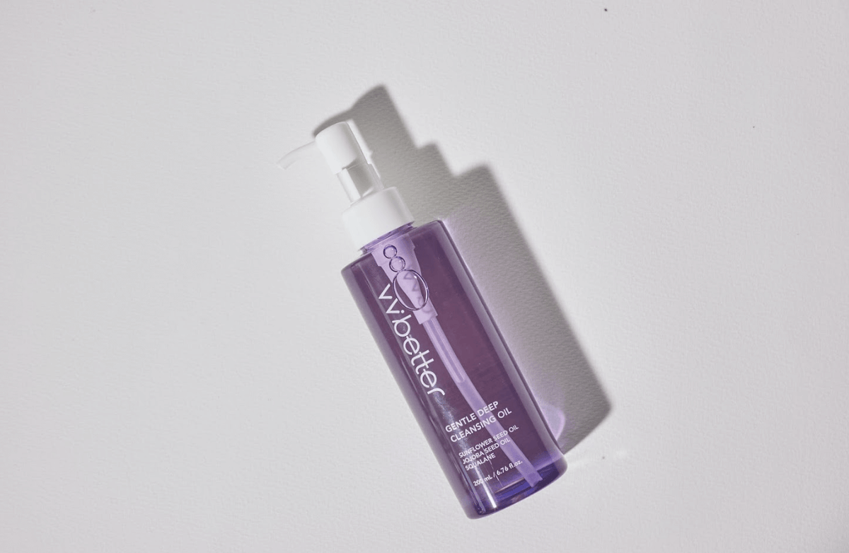 Gentle Deep Cleansing Oil, a clear purple bottle with a white pump head, lying on a white surface