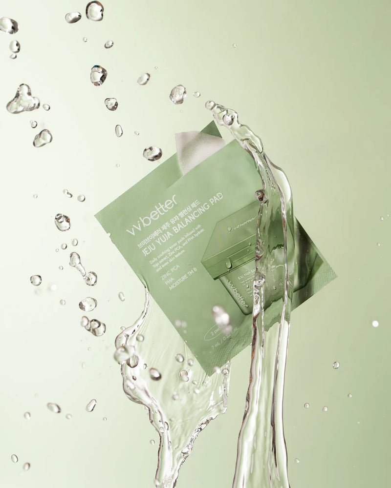 Sealed Jeju Yuja Balancing Pad mini pouch with water splashing around it on a light-green background