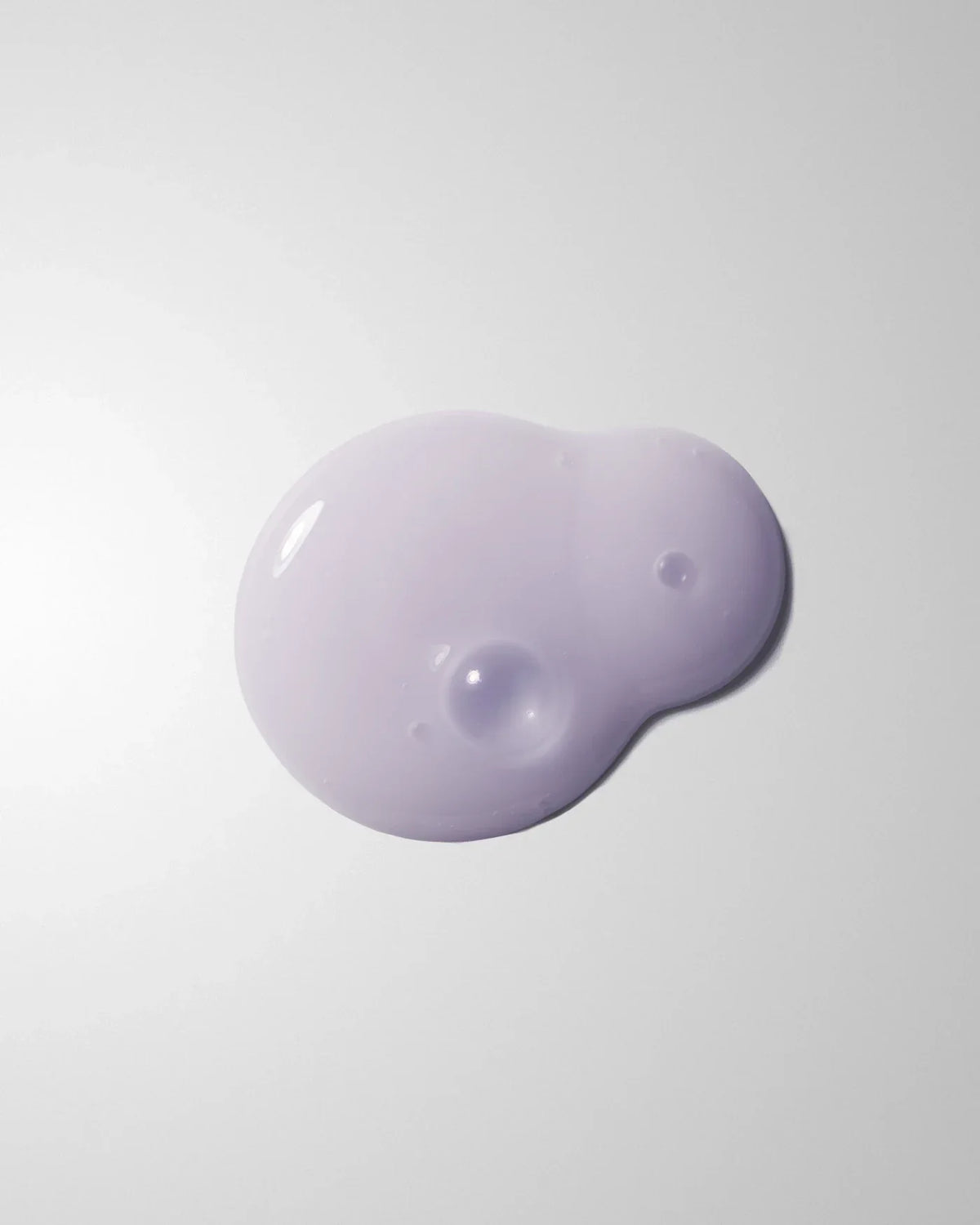 Small lavender-tinted swatch of Firming Bakuchiol PDRN Serum on a pale grey surface