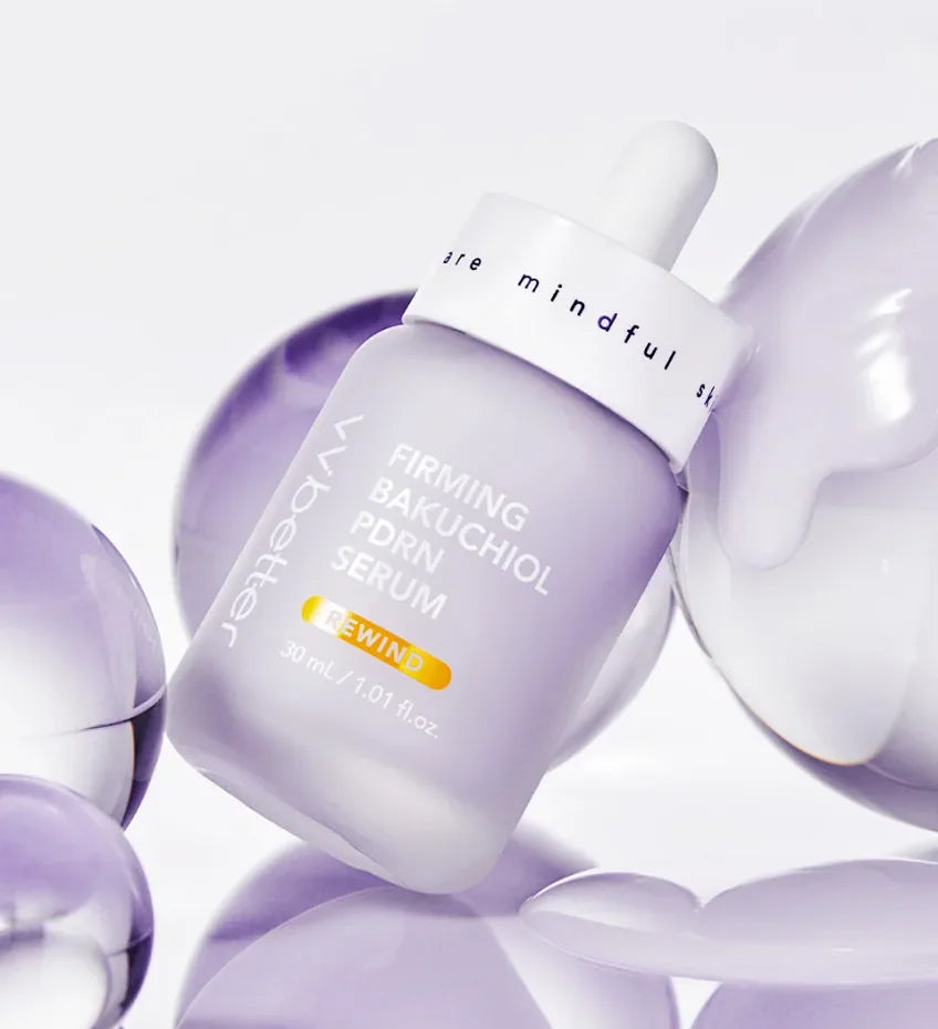 A lilac Firming Bakuchiol PDRN Serum bottle resting among glossy translucent lilac spheres