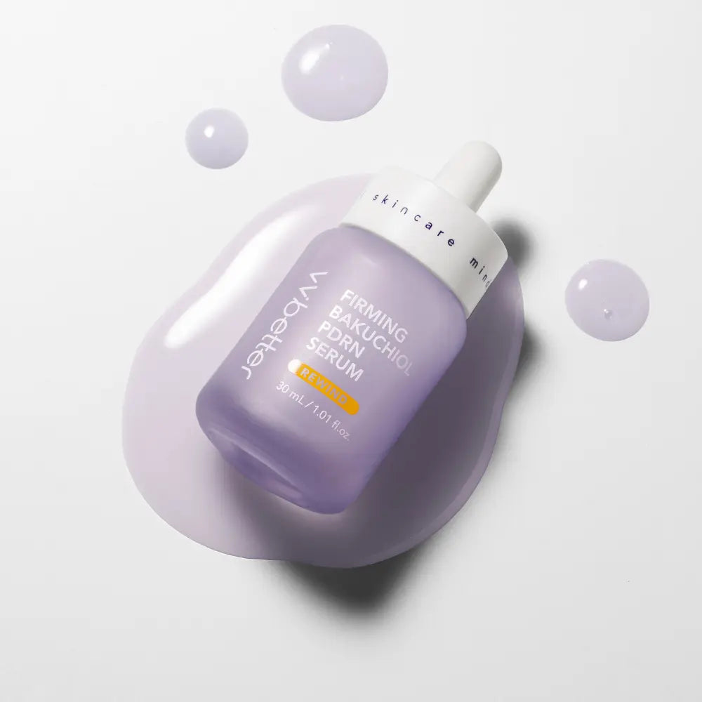 Firming Bakuchiol PDRN Serum — bottle lying in a pool of lavender serum with droplets, overhead view