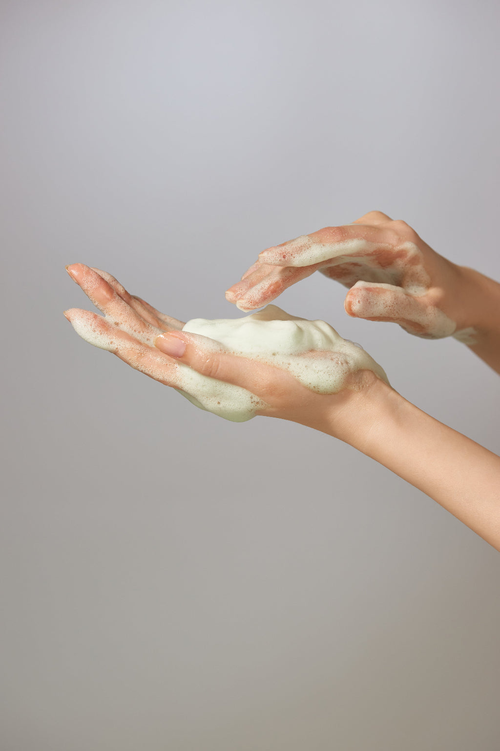 Jeju Yuja Balancing Bubble Cleanser — foam rubbed between two hands, close-up
