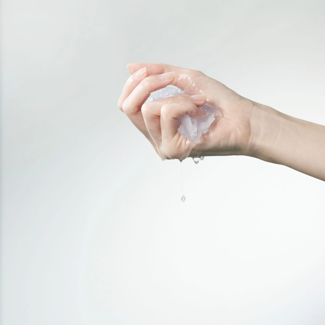 Rejuvenating Squalane Mask — sheet squeezed in a hand, clear essence dripping