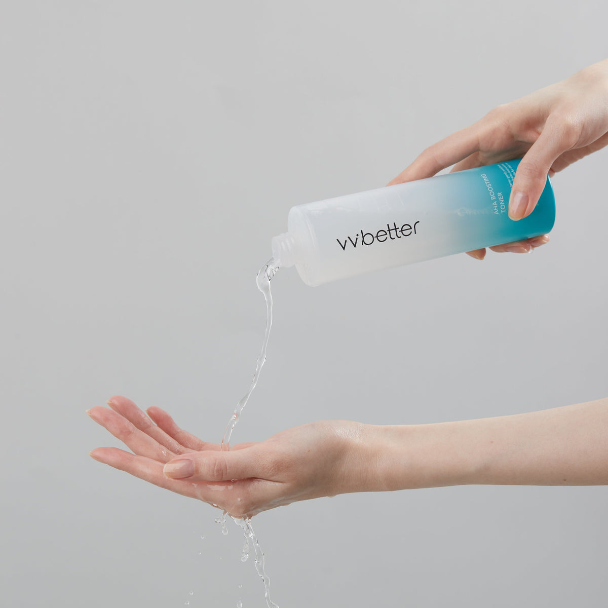 AHA Boosting Toner — clear toner poured from the open bottle into a cupped palm