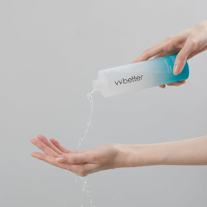 AHA Boosting Toner — clear toner poured from the open bottle into a cupped palm
