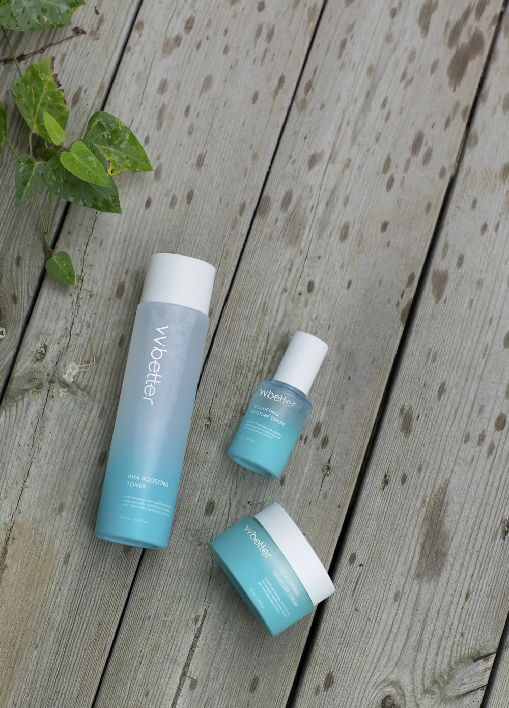 AHA Boosting Toner, Teca serum and Teca cream on a weathered wooden deck with green leaves
