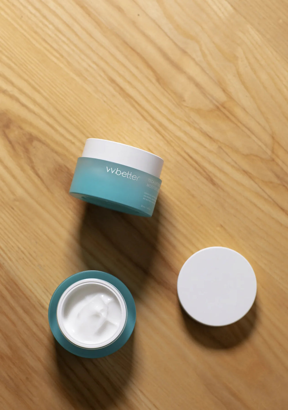 Teca Lifting Moisture Cream jar with its lid off on a wooden table