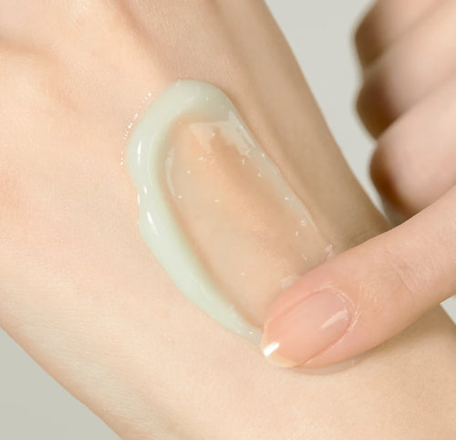 Fingertip spreading the gel cream on the back of a hand