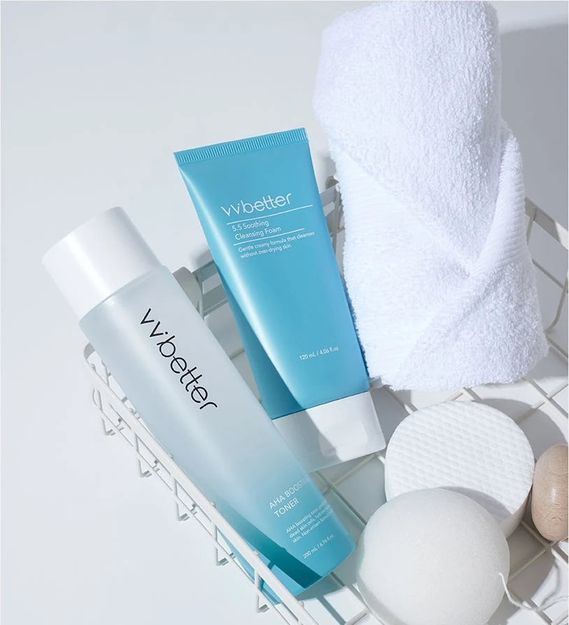 Bathroom basket with the foam tube, AHA Boosting Toner, a towel and a konjac sponge