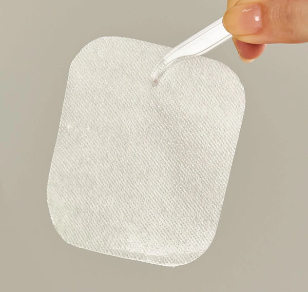 Textured Tencel pad with a pipette dropping essence onto it