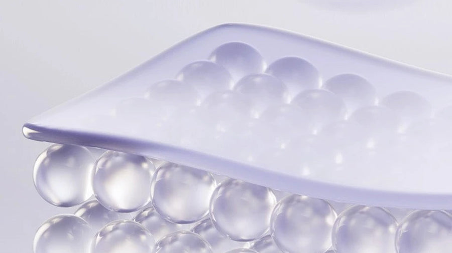 3D render of a translucent lilac sheet resting on layers of clear spheres