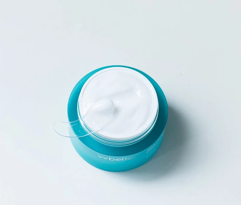 Open jar from above with a swirl of white cream and the spatula