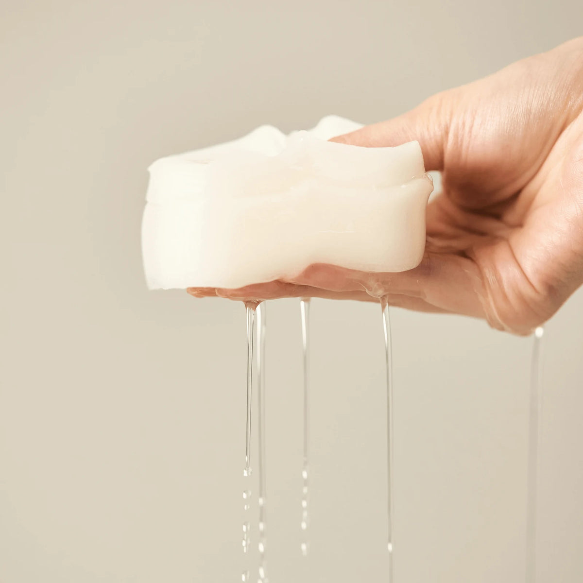 Jeju Yuja Balancing Pads, soaked in an essence with gluconolactone (PHA), squeezed in a hand so the essence drips