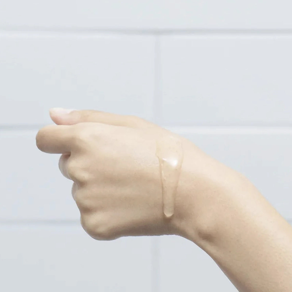 A thin clear swatch of hydrating serum on the inside of a wrist