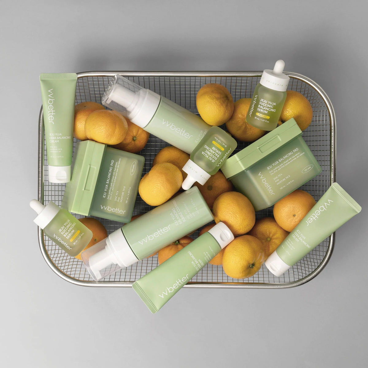 Ripe yellow Jeju yuja fruits in a wire basket with the pale green Jeju Yuja Line products