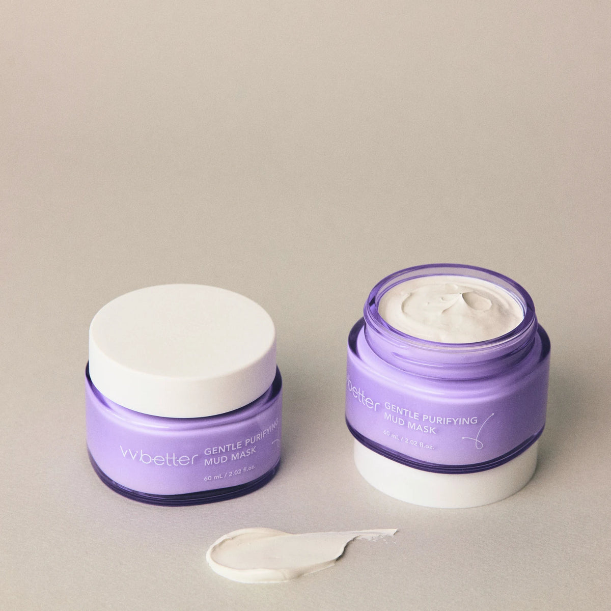 Two jars of Gentle Purifying Mud Mask, one open to show the soft grey-white kaolin clay, with a small swatch of the mask