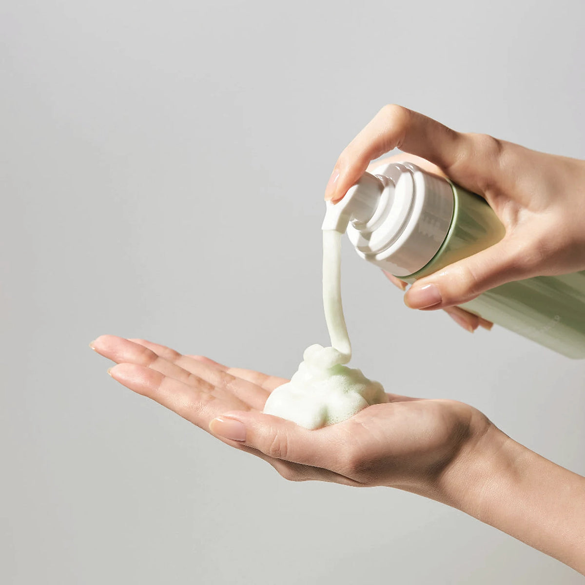 Dense white foam of the Jeju Yuja Balancing Bubble Cleanser, made with lactobacillus ferment, pumped into an open palm